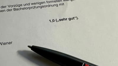 Nahaufnahme eines Gutachtens, in der Mitte des Blattes steht als einzelner Satz die Bewertung 1,0 sehr gut